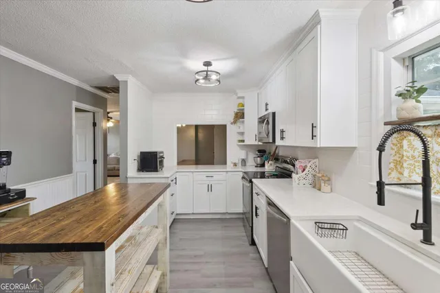 a kitchen with a sink stove top oven and refrigerator