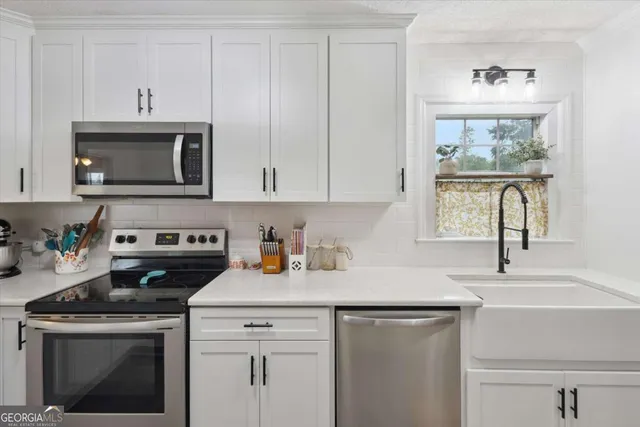a kitchen with cabinets stainless steel appliances and a sink