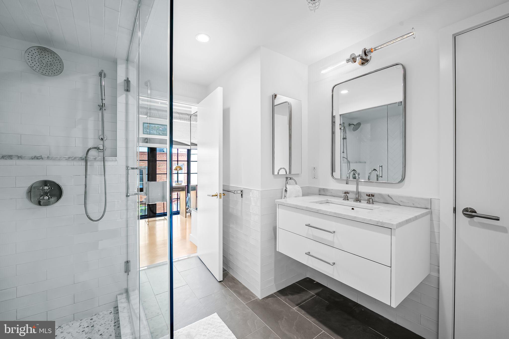 1220 Bank Street, Unit 304 Baltimore, MD 21202 - Photo 62 of 81 a bathroom with a double vanity sink mirror and shower