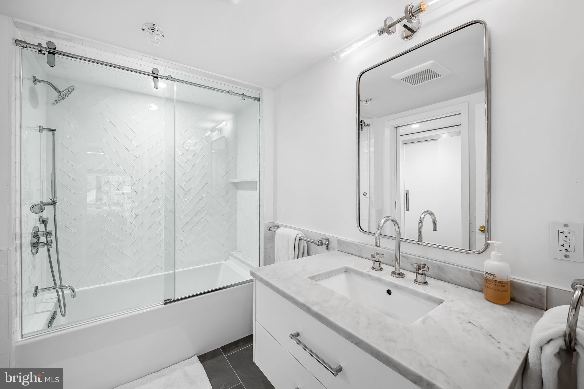 1220 Bank Street, Unit 304 Baltimore, MD 21202 - Photo 70 of 81 a bathroom with a double vanity sink mirror and shower