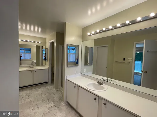 a bathroom with a sink a large mirror and a shower