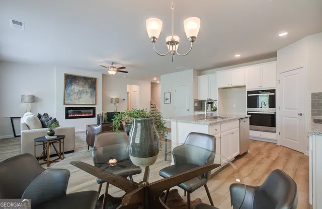 a view of a dining room with furniture a livingroom and chandelier