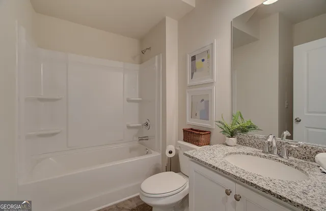 a bathroom with a granite countertop toilet a sink and a bathtub