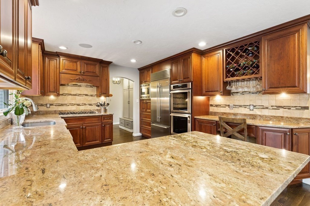 7 Kings Road Sharon, MA 02067 - Photo 12 of 41 a kitchen with stainless steel appliances kitchen island granite countertop a stove refrigerator and cabinets