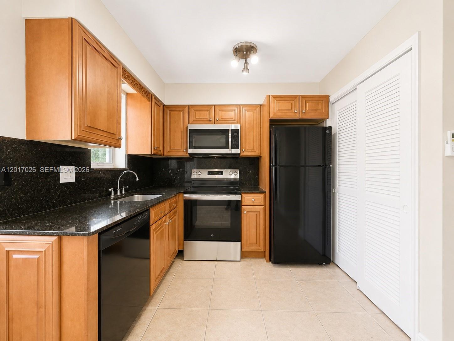3624 Jackson Street, Unit 2 Hollywood, FL 33021 - Photo 1 of 10 a kitchen with stainless steel appliances granite countertop a refrigerator a stove a sink and a microwave