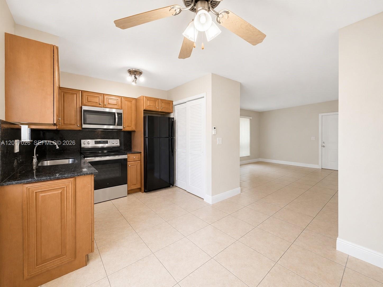 3624 Jackson Street, Unit 2 Hollywood, FL 33021 - Photo 3 of 10 a kitchen with granite countertop a refrigerator and a stove top oven