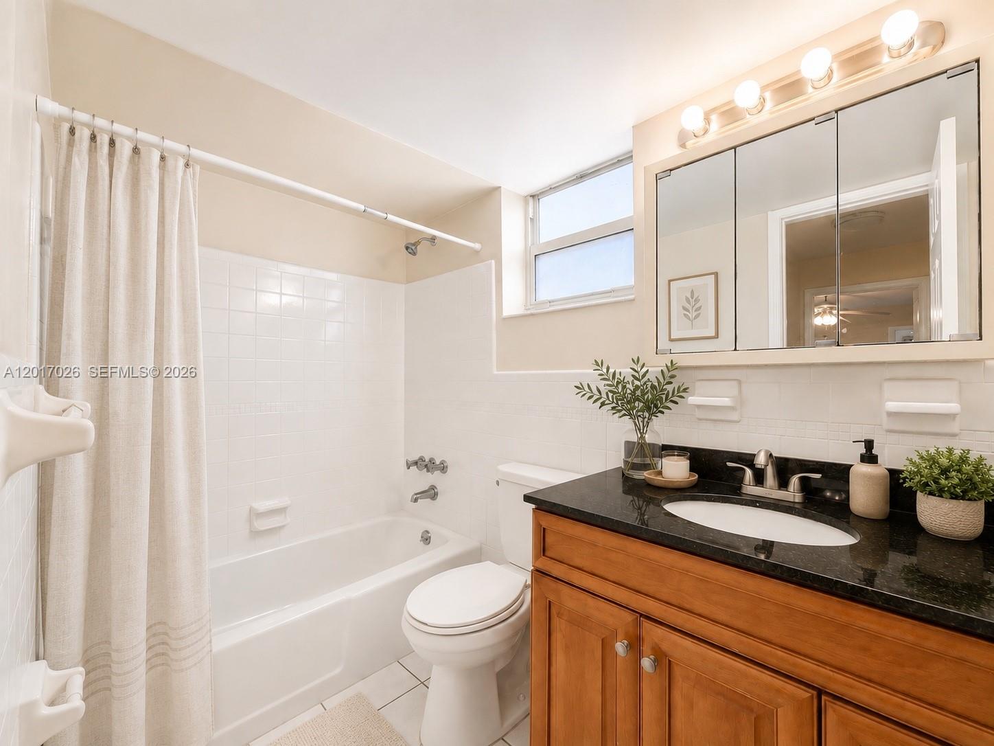 3624 Jackson Street, Unit 2 Hollywood, FL 33021 - Photo 8 of 10 a bathroom with a granite countertop sink a toilet and bathtub