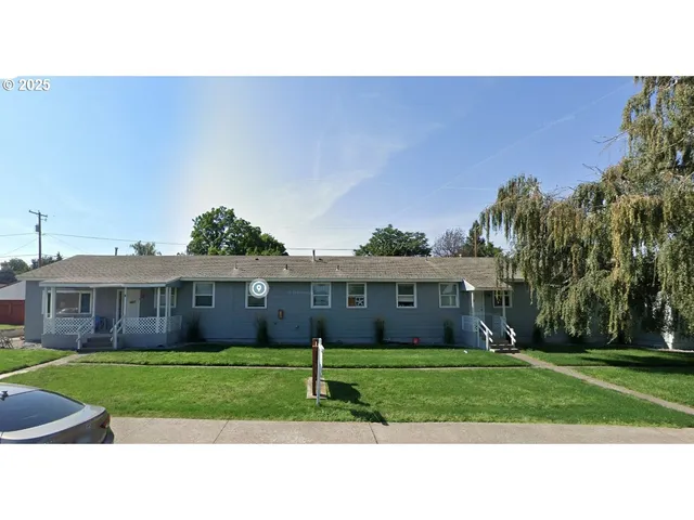 a front view of a house with a garden and yard