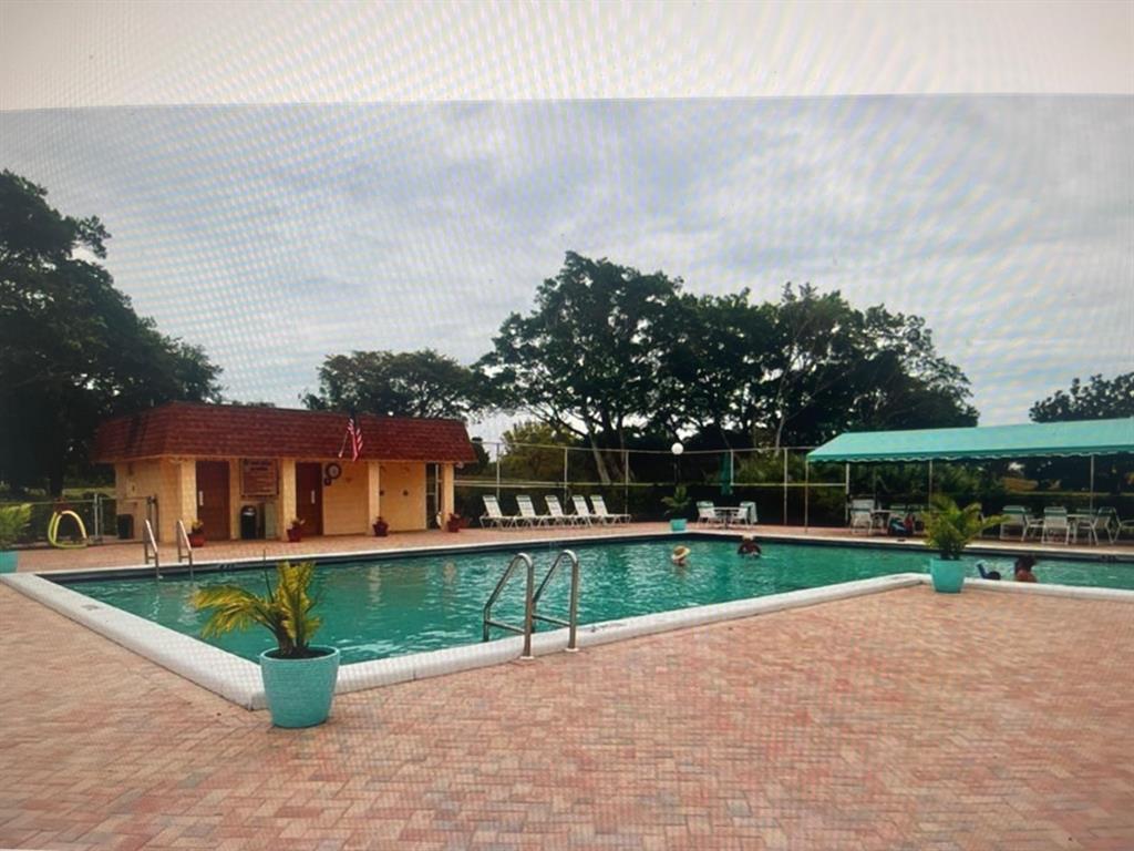 6300 Northwest 2nd Avenue, Unit 206 Boca Raton, FL 33487 - Photo 14 of 16 a view of a house with a yard and a fountain