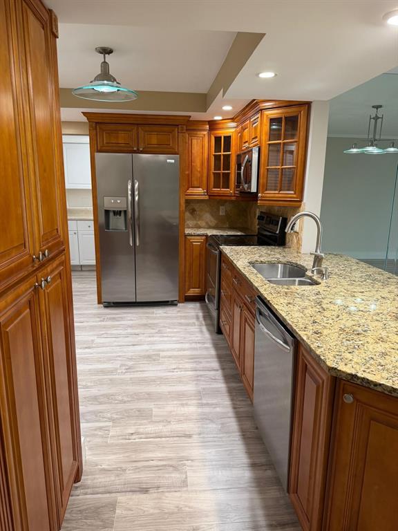6300 Northwest 2nd Avenue, Unit 206 Boca Raton, FL 33487 - Photo 4 of 16 a kitchen with stainless steel appliances granite countertop a refrigerator a sink dishwasher a stove and a dining table with wooden floor