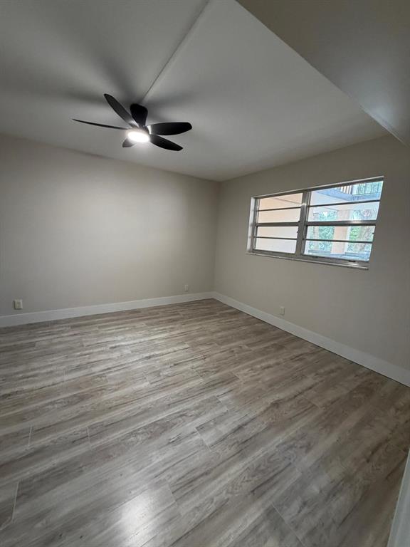 6300 Northwest 2nd Avenue, Unit 206 Boca Raton, FL 33487 - Photo 9 of 16 an empty room with wooden floor fan and windows