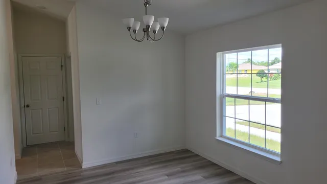 a view of empty room with wooden floor and window