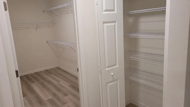 a view of walk in closet with empty racks