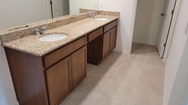 a bathroom with a granite countertop sink and a mirror