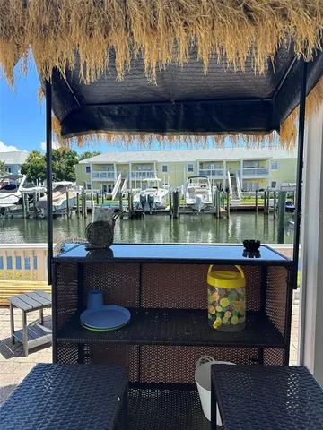 a view of a house with table and chairs under an umbrella
