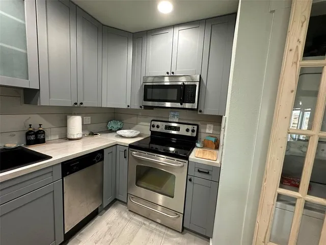 a kitchen with stainless steel appliances granite countertop a sink a stove and cabinets
