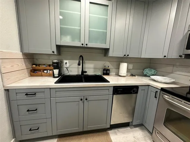 a kitchen with stainless steel appliances granite countertop a refrigerator a stove a sink a microwave a dining table and chairs