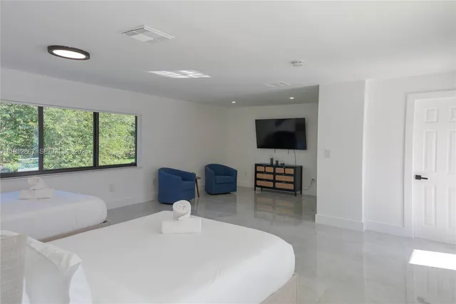 a bedroom with furniture and a flat screen tv