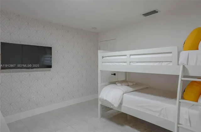 a bedroom with a bed and flat screen tv