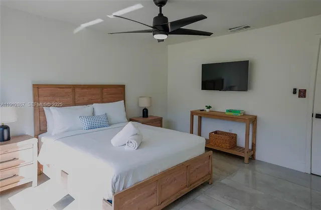 a bedroom with a bed and a flat screen tv