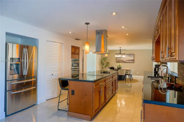a living room with couches chairs and kitchen view with wooden floor