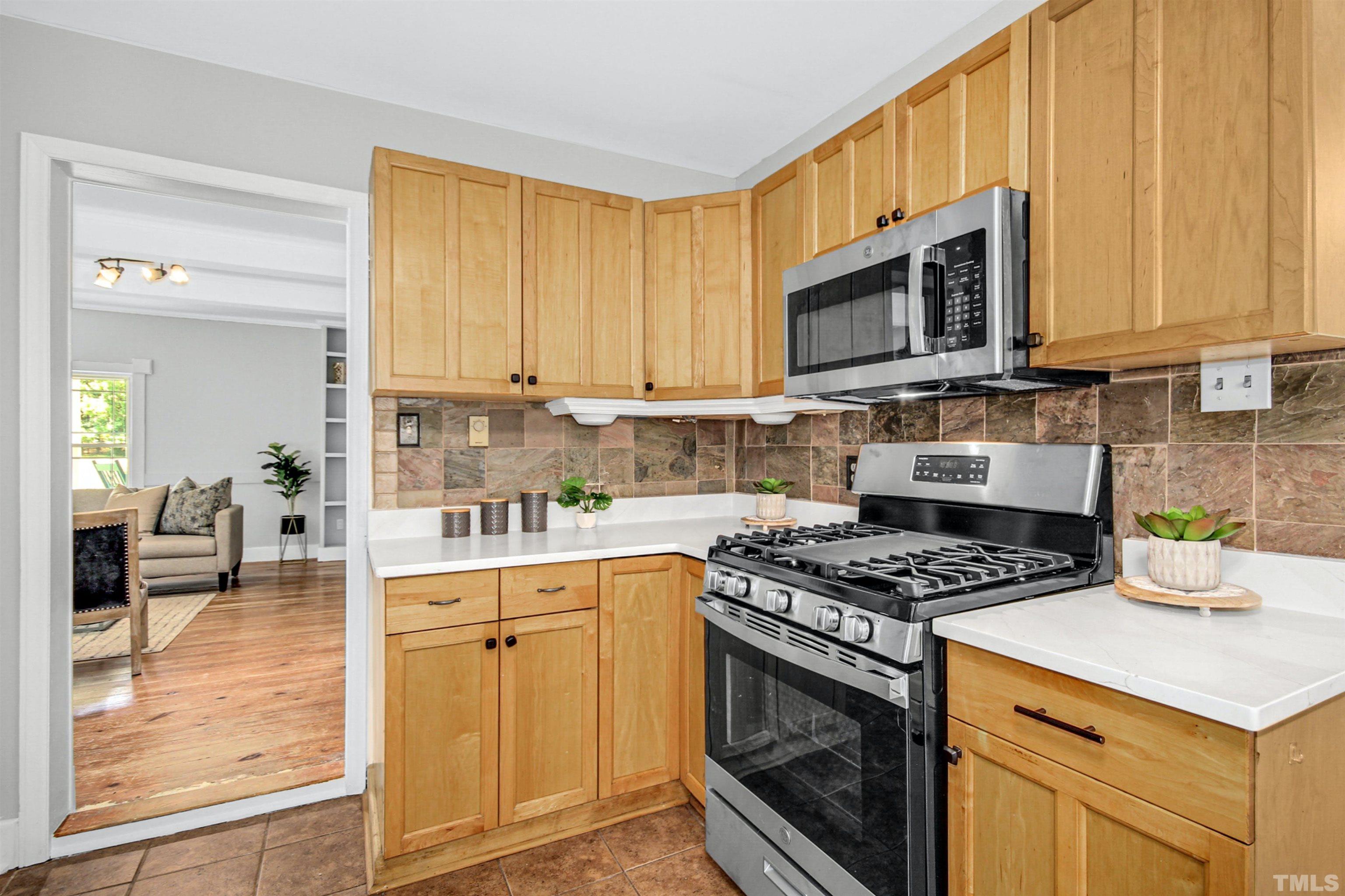 4610 Hall Road Rougemont, NC 27572 - Photo 28 of 43 a kitchen with stainless steel appliances granite countertop a stove a sink and a microwave