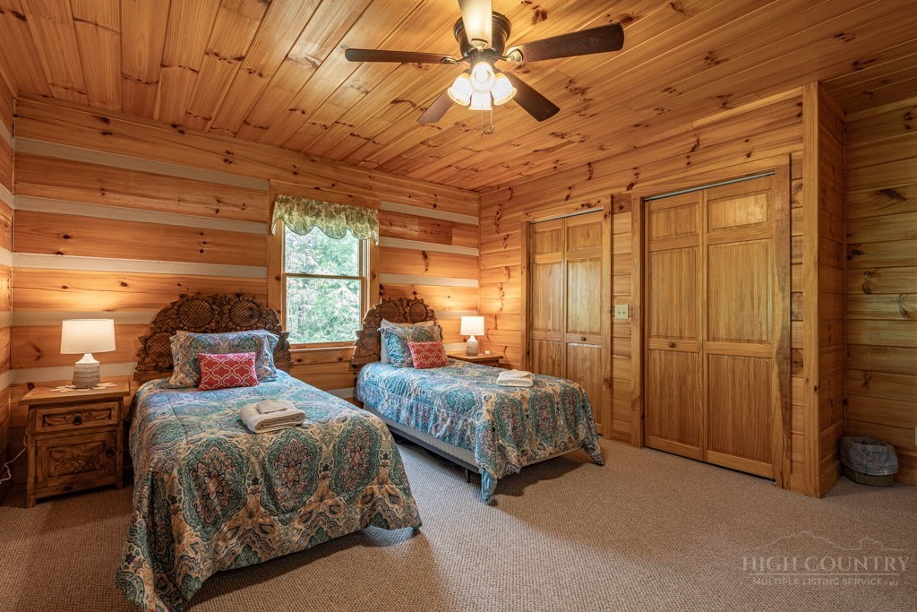 197 Woodby Ridge Road Vilas, NC 28692 - Photo 18 of 45 a bedroom with two beds and a chandelier