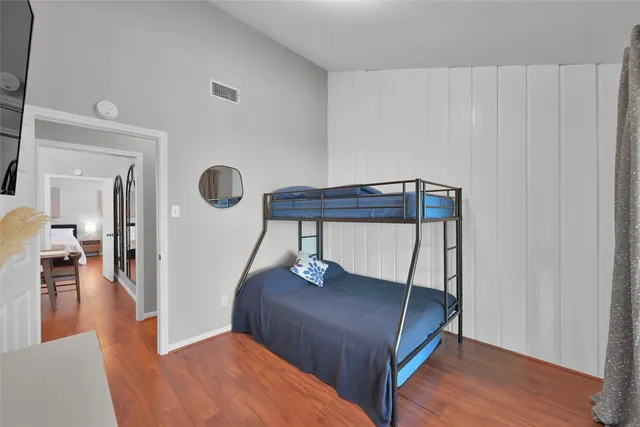 a bedroom with a bed and wooden floor
