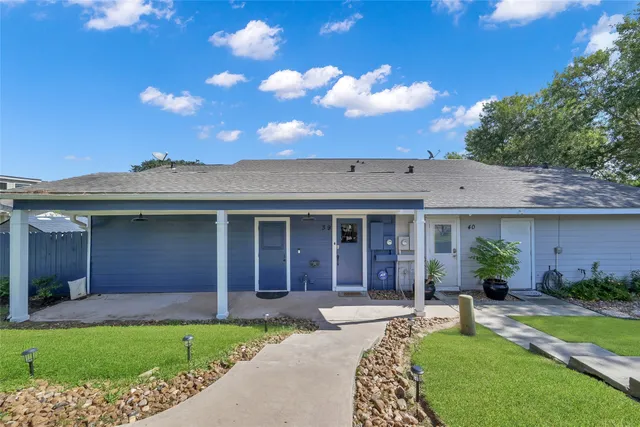 a view of a house with a yard and potted plants
