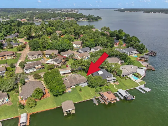 an aerial view of a house with a garden and lake view