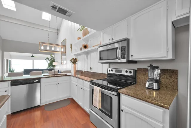 a kitchen with stainless steel appliances granite countertop a sink and cabinets