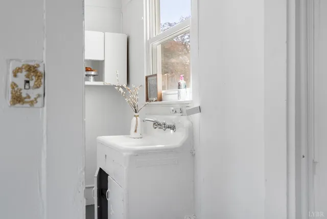 a bathroom with a sink a mirror and a window