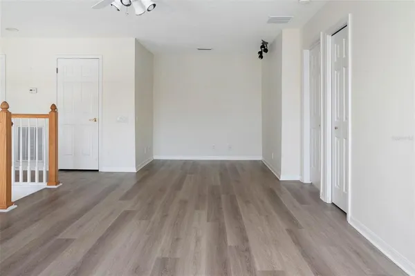 a view of an empty room with wooden floor