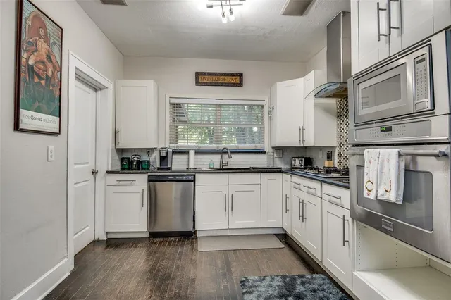 a kitchen with stainless steel appliances granite countertop a stove a sink and a refrigerator