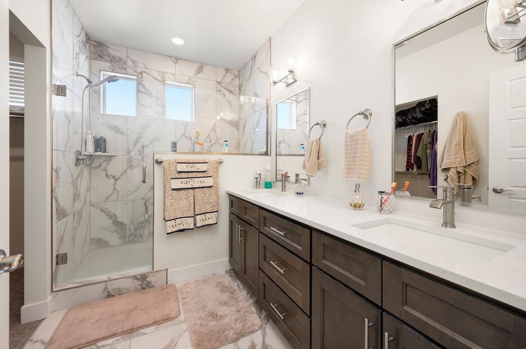 1694 Tungsten Way Fruita, CO 81521 - Photo 20 of 22 a bathroom with a double vanity sink mirror and shower