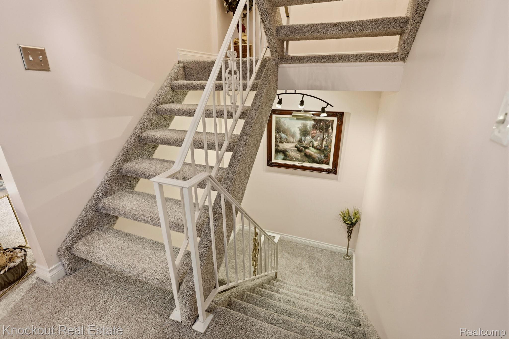 249 Churchgrove Road Frankenmuth, MI 48734 - Photo 30 of 44 Carpeted staircase with white metal railings