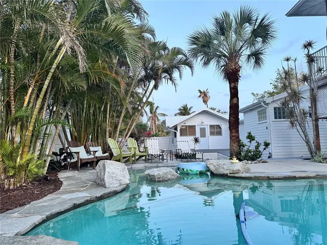 a view of a house with pool and sitting area
