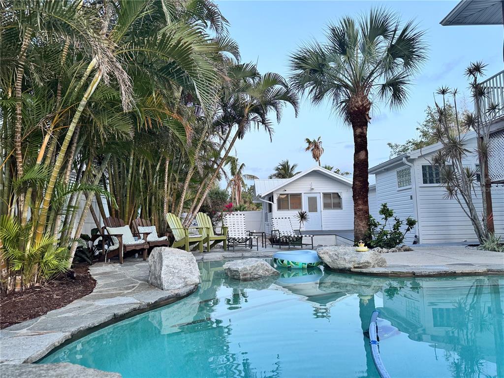 a view of a house with pool and sitting area
