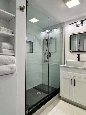 a bathroom with a shower sink and mirror