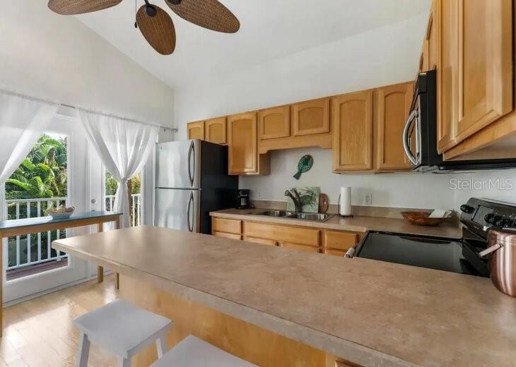 701 Broadway Street Longboat Key, FL 34228 - Photo 32 of 33 a kitchen with stainless steel appliances granite countertop a sink dishwasher stove and refrigerator with wooden floor