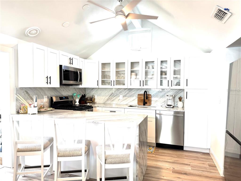 701 Broadway Street Longboat Key, FL 34228 - Photo 6 of 33 a kitchen with stainless steel appliances kitchen island granite countertop a sink and cabinets