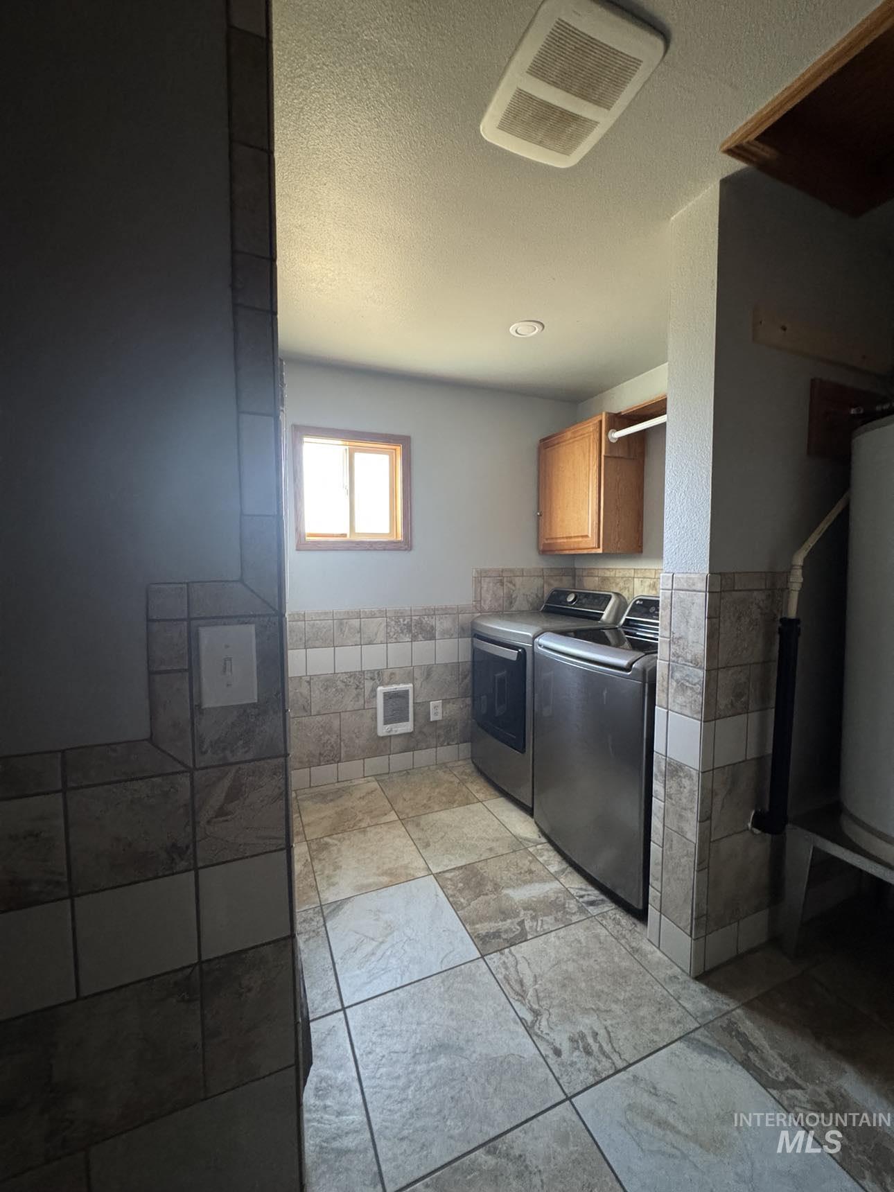 40336 Sr 129 Anatone, WA 99401 - Photo 13 of 29 Laundry area featuring tile walls, cabinet space, washer and clothes dryer, wainscoting, and heating unit
