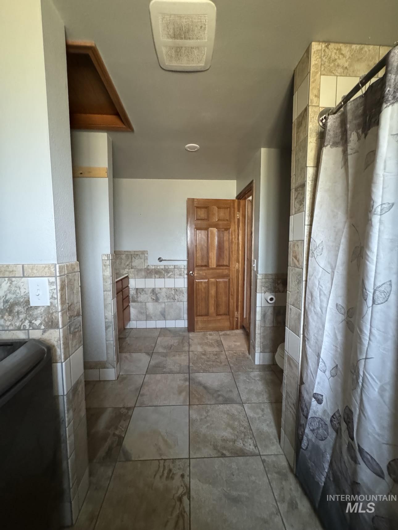 40336 Sr 129 Anatone, WA 99401 - Photo 14 of 29 Full bath with tile walls, a shower with shower curtain, and wainscoting