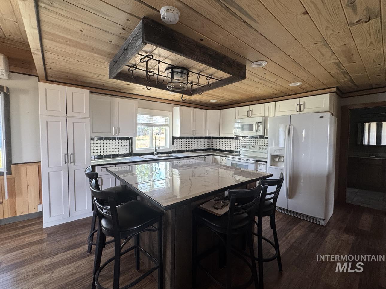40336 Sr 129 Anatone, WA 99401 - Photo 4 of 29 Kitchen featuring wooden ceiling, white appliances, dark wood-style flooring, white cabinets, and a wainscoted wall