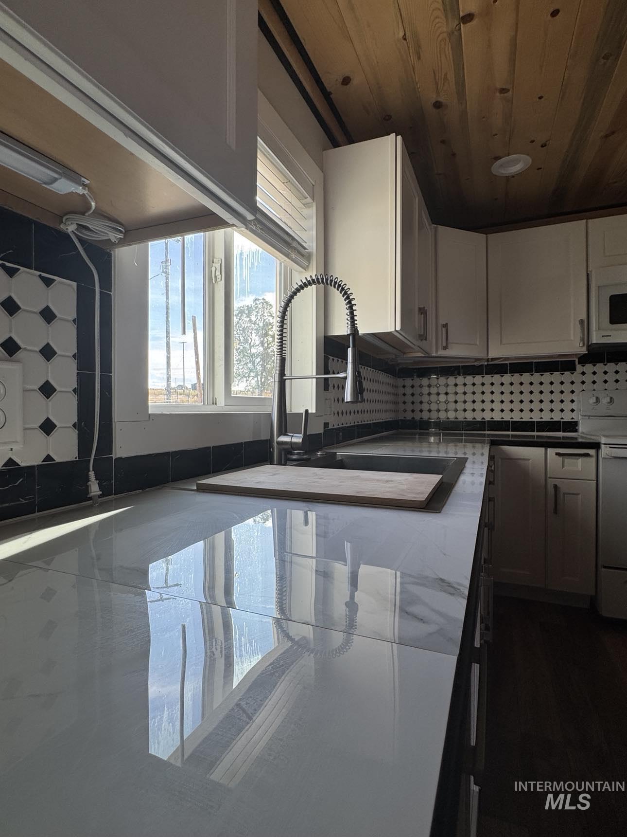 40336 Sr 129 Anatone, WA 99401 - Photo 5 of 29 Kitchen with backsplash, white appliances, wood ceiling, and white cabinets