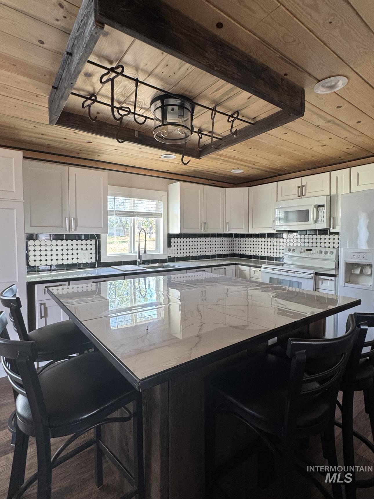 40336 Sr 129 Anatone, WA 99401 - Photo 6 of 29 Kitchen featuring wooden ceiling, white appliances, decorative backsplash, a center island, and white cabinets