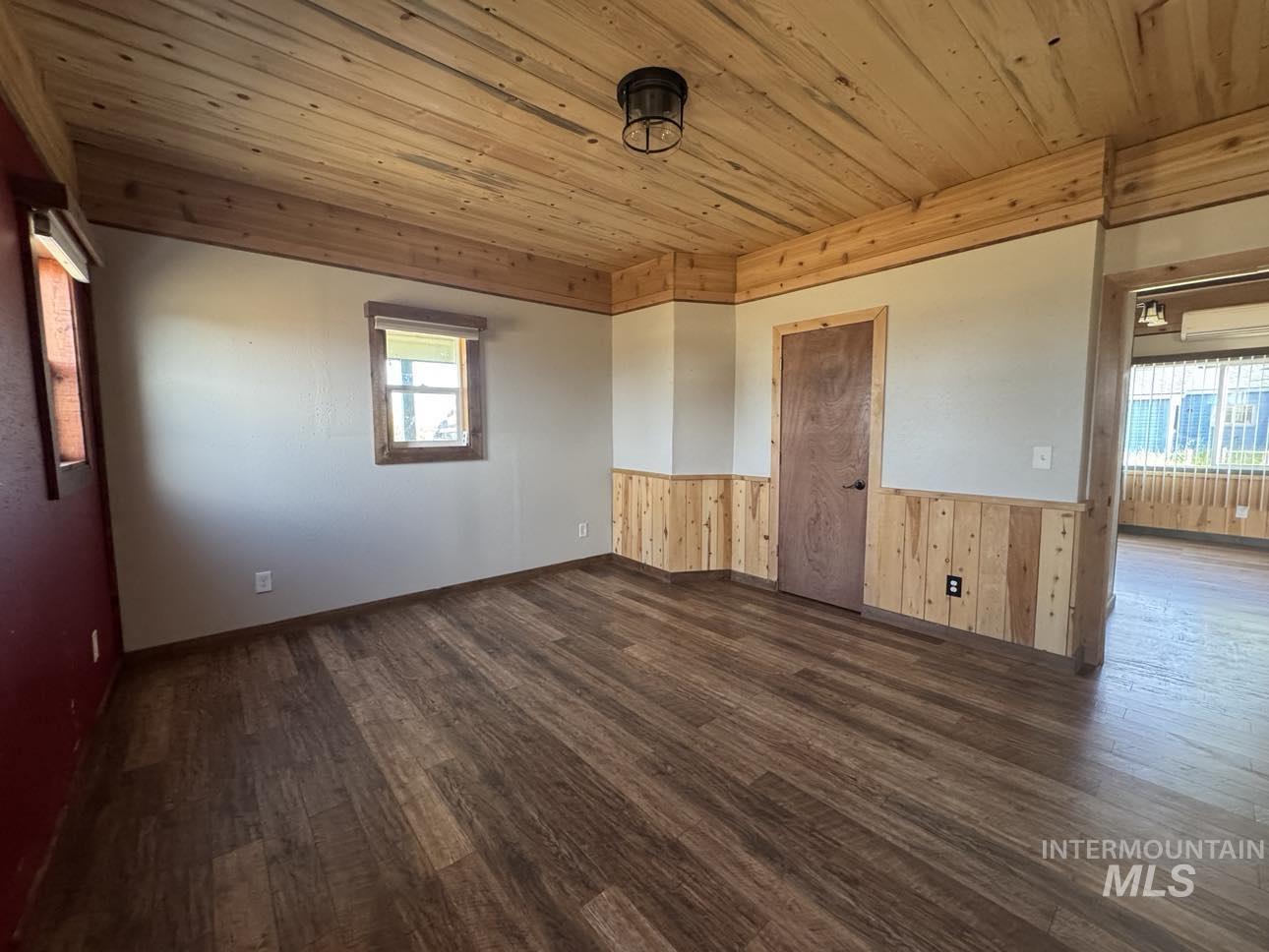 40336 Sr 129 Anatone, WA 99401 - Photo 9 of 29 Spare room featuring dark wood-style flooring, a wainscoted wall, plenty of natural light, wooden ceiling, and wood walls