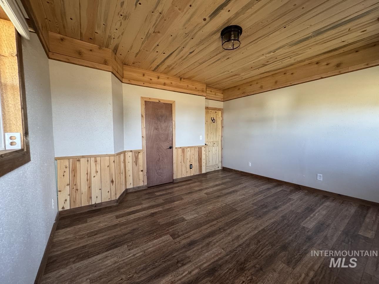 40336 Sr 129 Anatone, WA 99401 - Photo 10 of 29 Spare room with dark wood-style flooring, wood ceiling, wooden walls, and wainscoting