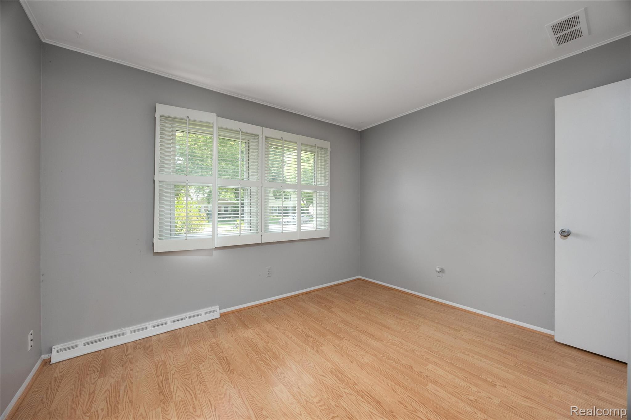 4942 Butler Drive Troy, MI 48085 - Photo 16 of 33 Room featuring wood-finish flooring, neutral gray wall tones, and white trim