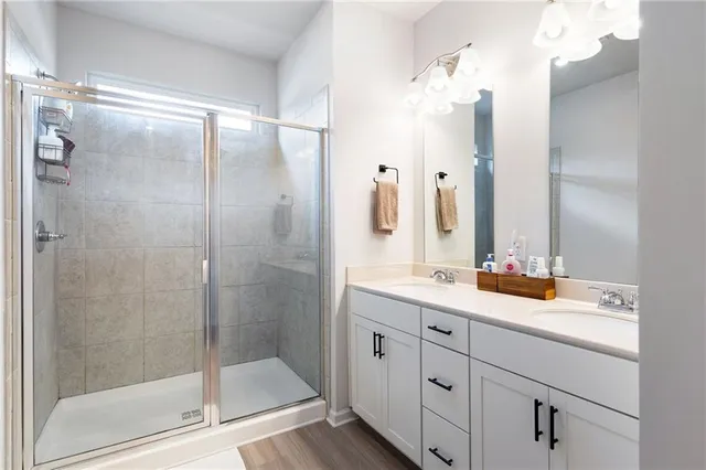 a bathroom with a double vanity sink mirror and shower